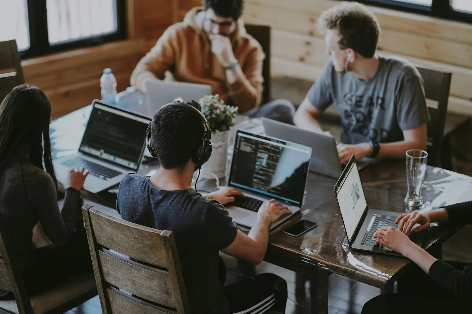 A team working on laptops around a shared table