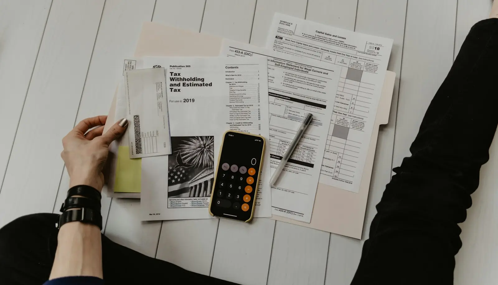 Financial documents, a calculator and a pen on a desk