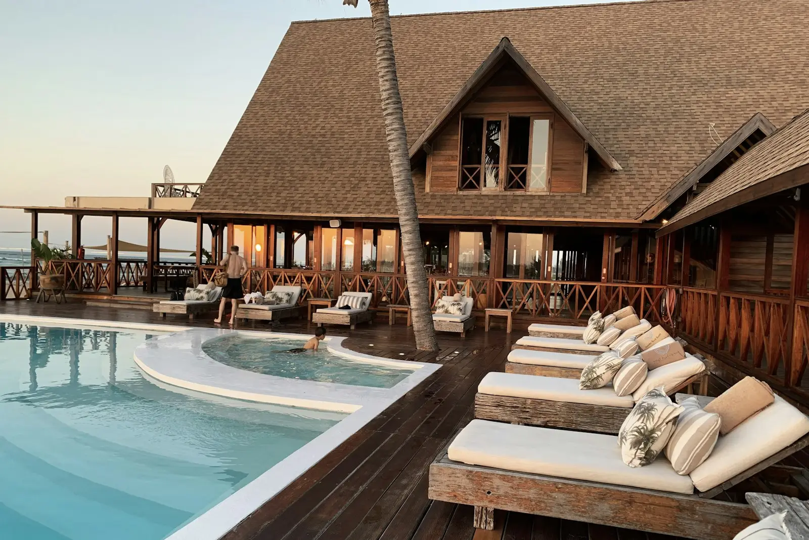 A resort hotel's poolside terrace with loungers at sunset