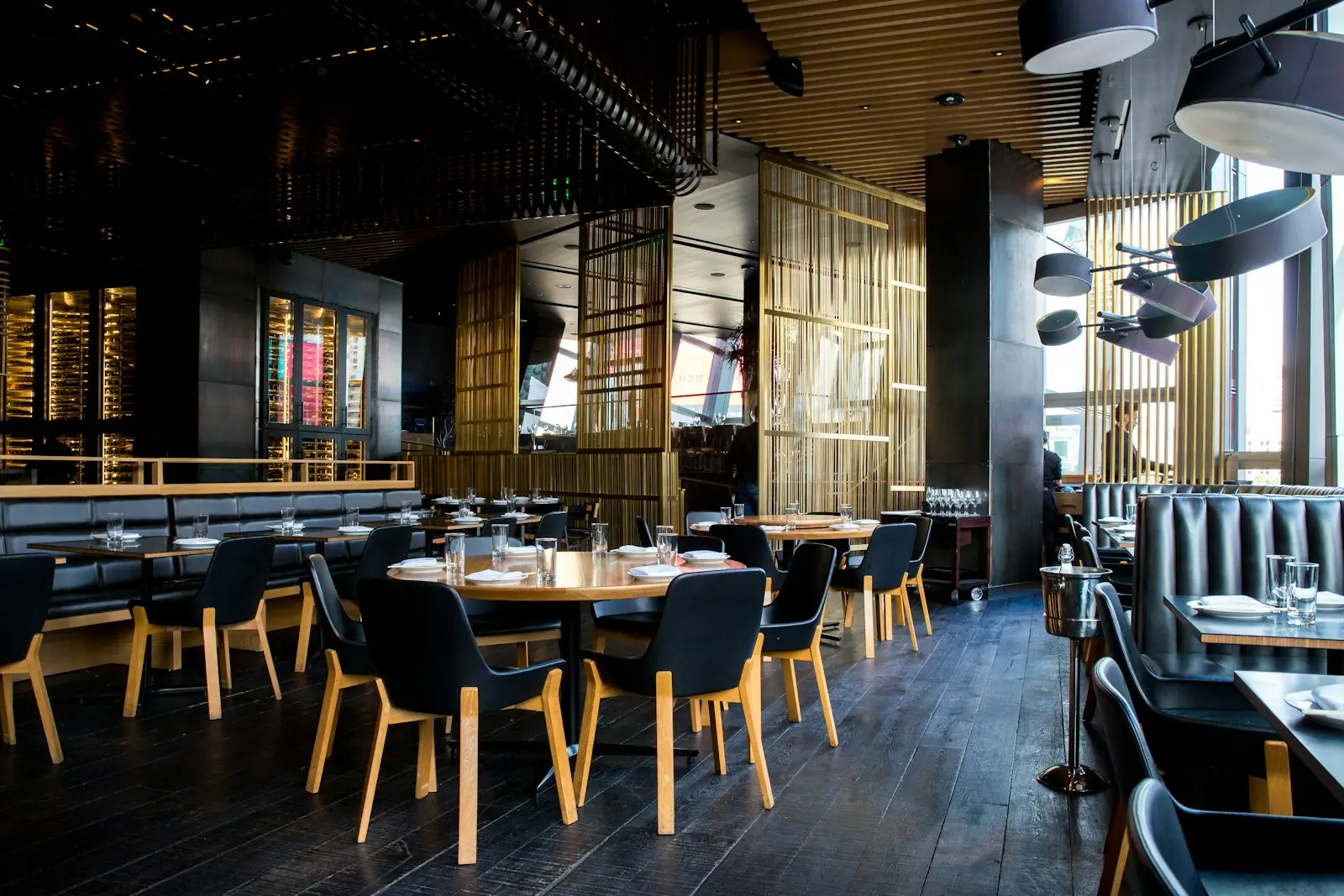 A modern restaurant dining room with set tables and warm lighting