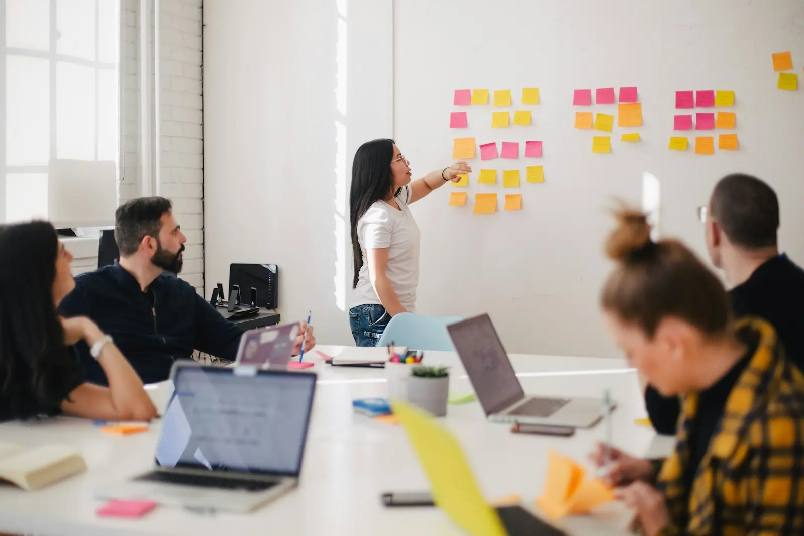 A marketing team planning together at a wall of sticky notes